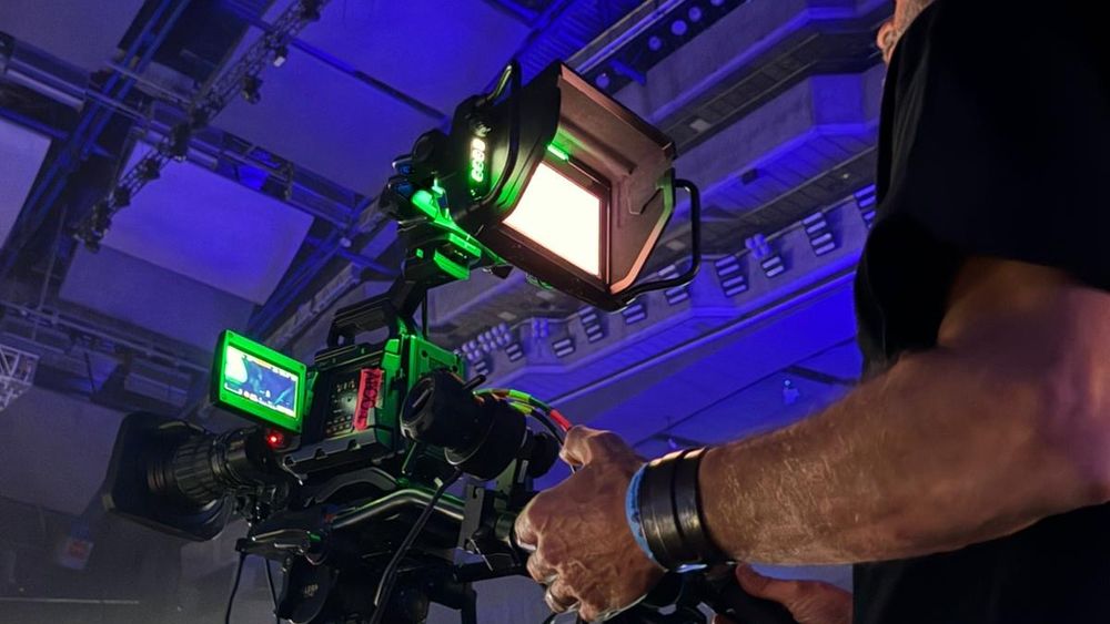 Operador de cámara broadcast siguiendo un concierto en directo con intercom y monitor de campo